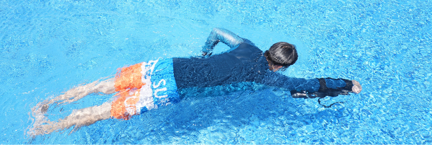 Person swimming in a pool with clear blue water